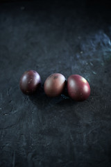 Dark purple eggs on a rough cement background