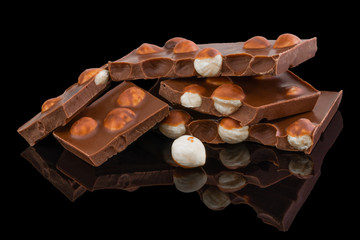 milk chocolate pieces with nuts on a dark background