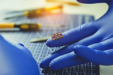 Cropped photo of man keeping microchip on finger