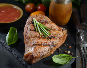 grilled  beef steak on black slate with spices.