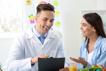 Fototapeta premium Young woman visiting nutritionist in weight loss clinic