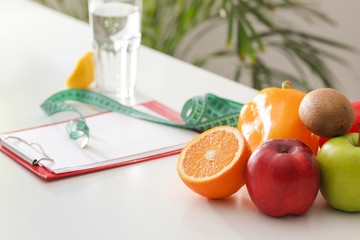 Fresh fruits and vegetables on table of nutritionist in office