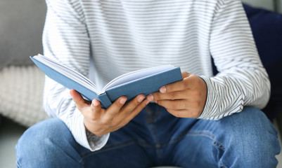 Fototapeta premium African-American teenage boy reading book at home