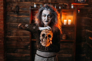 Witch reads the spell, ritual with human skull
