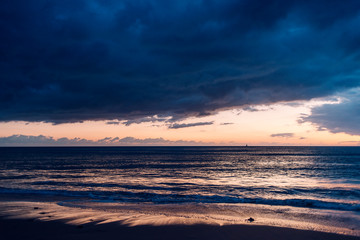 colorful sunset on a beach with stormy sky