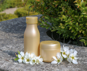 Fototapeta na wymiar Cosmetic cream, balm, cosmetic milk and white flower