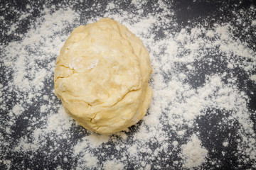 Raw dough is on the table with flour before cooking cottage cheese cookies