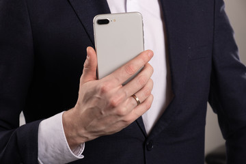 Man's Hand Touching Screen of Smartphone in Office