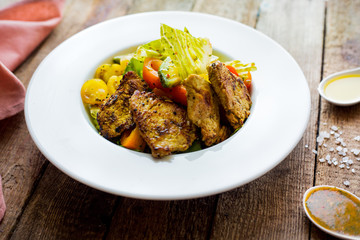 Chicken salad with cherry and vegetables. Wooden table. Salt. Ingridients.