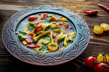 Vegetable soup with egg, pepper and spices. Cherry. Homemade. Wooden table. Dinner.