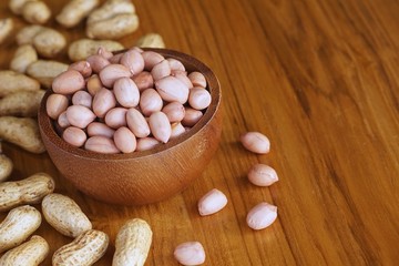 Peanut in wooden bowl on classic wooden table background, peanut butter