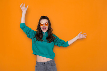 Cropped photo of smiling brunette Caucasian girl wearing stylish eyeglasses and dancing