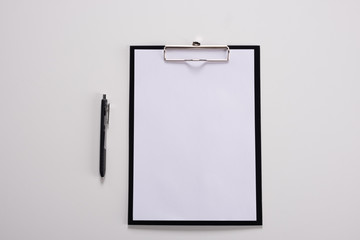 Tablet with writing paper with pen on white table