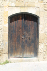 Weathered wooden front door in stone wall
