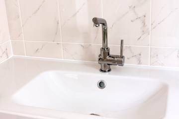 Faucet with white sink in bathroom.