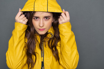Close up of calm Caucasian girl dressed in yellow raincoat in studio