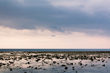 Plane flies through  Nature Nai Yang Beach Beach in Phuket from Thailand