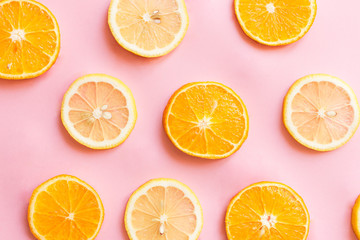 Pink background with chunks of lemon and oranges