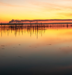 Obraz premium Sunset landscape views of a natural lagoon with a sunset and mountains in the background