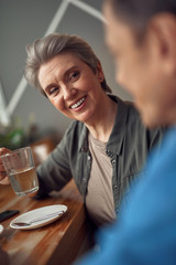 Happy smiling aged woman looking to her friend