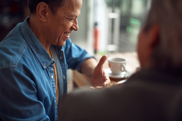 Happy smiling aged man enjoying meeting in cafe