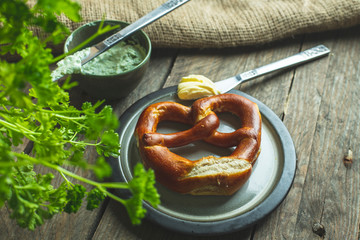 german pretzel with butter on a rustic wooden table