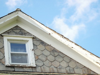 roof gable peak slate shingles blue sky wispy clouds