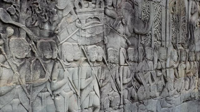 Close view of historical bas-reliefs on the stone wall in Bayon temple. Built in 12-13th century it stands at the centre of Jayavarman's capital, Angkor Thom. Cambodia