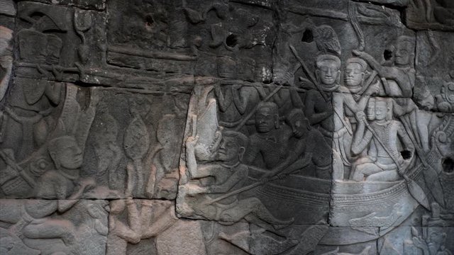 Close view of detailed bas-reliefs on the stone wall in Bayon temple. Built in 12-13th century it stands at the centre of Jayavarman's capital, Angkor Thom. Cambodia