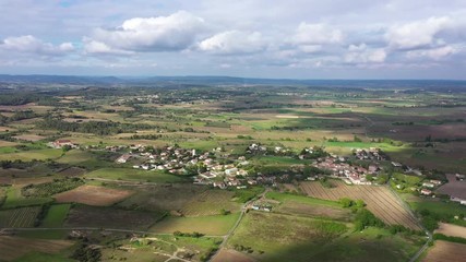 Beautiful rural aerial drone shot over Campagne village vineyards and crop fields around sunset with clouds 