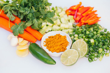 Fresh vegetable assortment on white background. Greenery, cut limes, pepper, carrot, cucumber and lime. Healthy nutrition concept. Vegeterian products