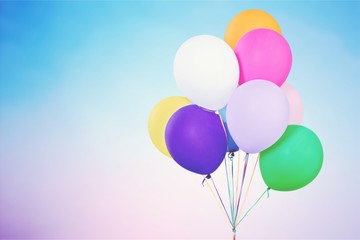 Bunch of colorful balloons on blurred blue background. Bokeh