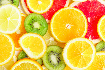 Fototapeta na wymiar citrus slices - kiwi, oranges and grapefruits on white background. Fruits backdrop