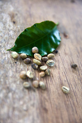 Kopi Luwak coffee beans and leaf on wooden table