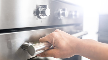 Man open an electric oven  and bakes a cake in the kitchen