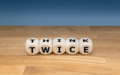 Dice form the words "THINK TWICE".