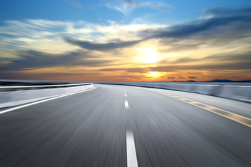 Naklejka premium Zamazana w ruchu autostrada w chmurach zmierzchu