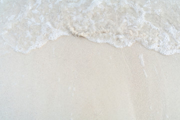 Fototapeta na wymiar Soft wave with foam of ocean on the sandy beach
