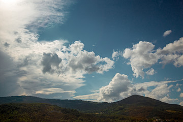 Obraz premium Panoramic view of a landscape with large cumulus cloud formations.