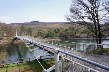 Fototapeta na wymiar Stahl-Hängebrücke Victor-Neels-Brücke über dem Stausee im Urfttal im Nationalpark Eifel