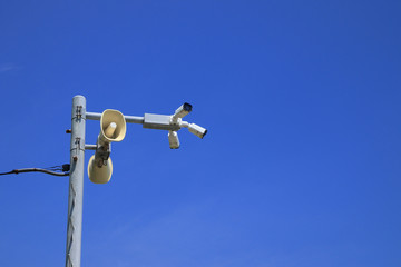 Loudspeakers and CCTV security cameras beach area on blue sky