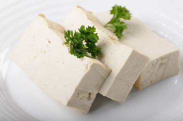 Soy Bean curd tofu on clay dish closeup. Non-dairy alternative substitute for cheese