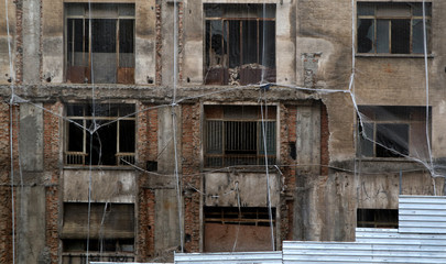 Scary old building windows. Ruined abandoned construction.