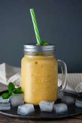 Homemade mango, lemon ice-cream or milk shake in mason jar cups, rustic wooden background. Vintage style.