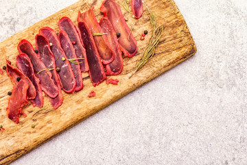 Basturma, dried tenderloin of beef meat, jerky, thinly sliced. Dry rosemary, pepper mix on vintage...