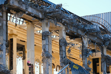 Demolished destructed building ruins. Demolition site in european city. Ruined house on a bright blue sky on a sunny day.