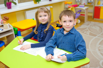 Fototapeta premium children at school in kindergarten, children learn to write