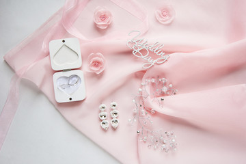 Obraz na płótnie Canvas white box for wedding rings on pink chiffon on white paper background - top view