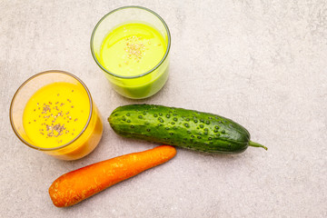 Organic cucumber and carrot smoothies with sesame and chia seeds. Healthy diet concept. On a stone background, copy space, top view.