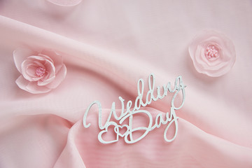 decorative fabric flowers, bridal jewelry on pink chiffon on white paper background - top view